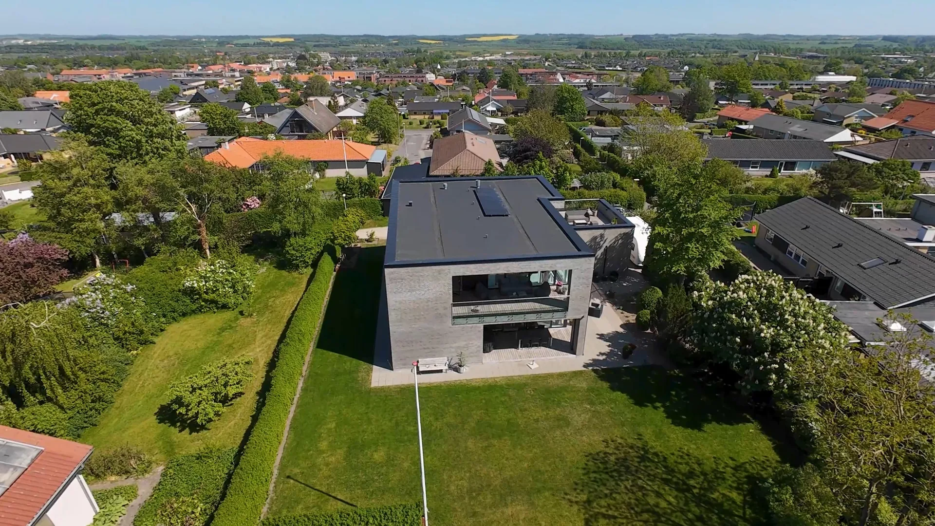 Dronefoto af hus, have og omkringliggende område